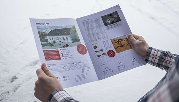 Två händer som håller i en katalog om taksäkerhet från Bender Safe.