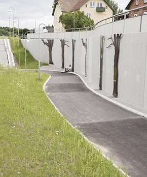 En gång- och cykelväg som har T-stöd bredvid för att ta upp höjdskillnaden. 