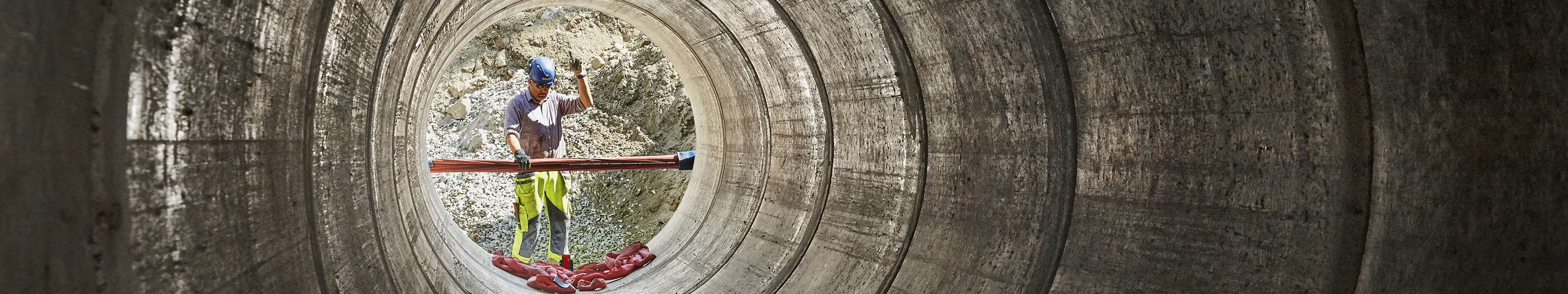 En man jobbar med montering av ett stort rör. 