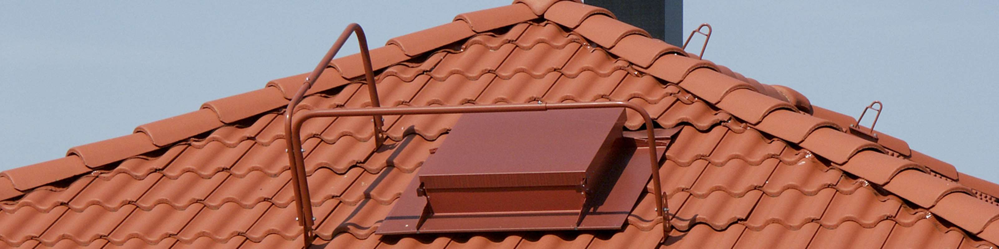 Ett tak med tegelröda takpannor i betong med taksäkerhet på. 