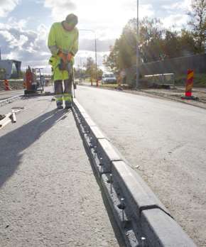 En man sätter Spikma kantsten. 