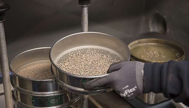 Siktning av sand och grus för kontroll.