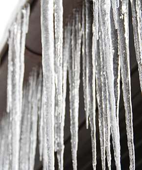 Många istappar som hänger tätt från ett tak.