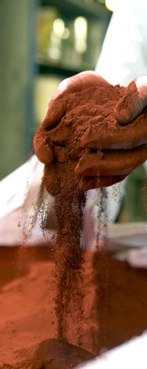 Två händer som håller i rött färgpigment.